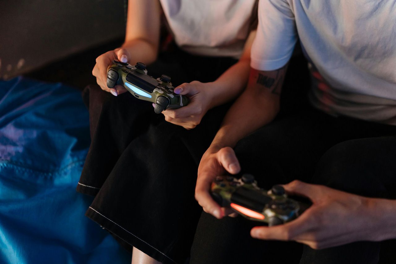 Two people playing video games with game controllers.