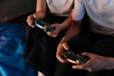 Two people playing video games with game controllers.